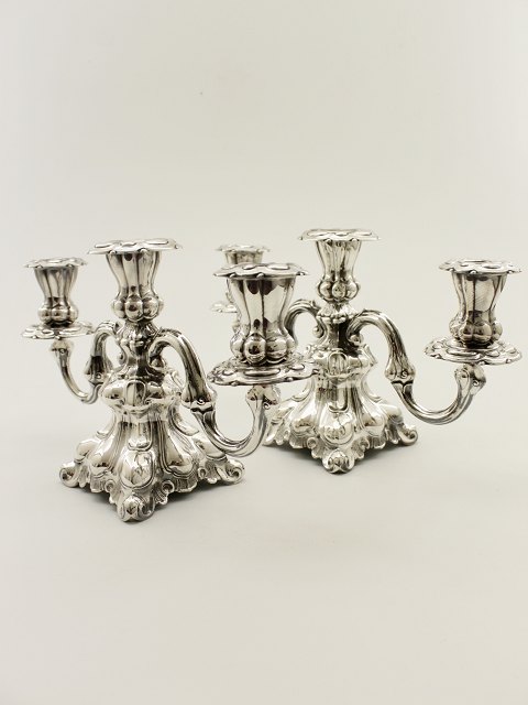 A pair of three-armed silver nycoco candlesticks sold